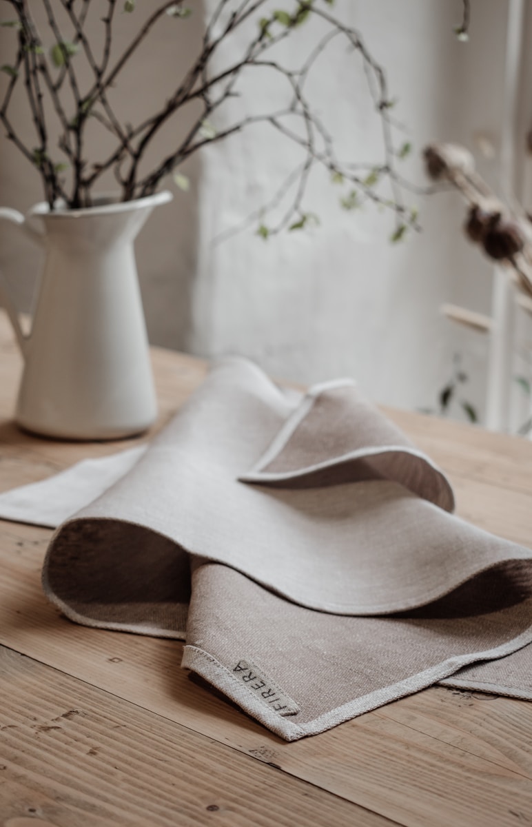 white ceramic vase on brown wooden table